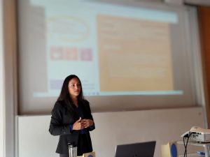 Mujer exponiendo sobre consultoría estratégica en diversidad, inclusión y bienestar laboral en un entorno académico